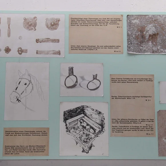 Ausstellungtafel zum Alamanenfriedhof Kirchheim im Ries mit Ausgrabungsfotos von Skeletten und Fundstücken mit dazugehöriger Beschreibung.
