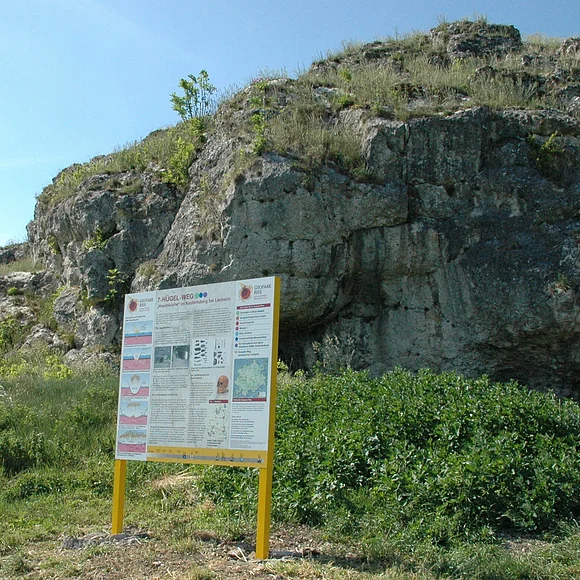 Hexenküche bei Lierheim Außenansicht auf die Hexenküche bei Lierheim mit davor stehender Infotafel.