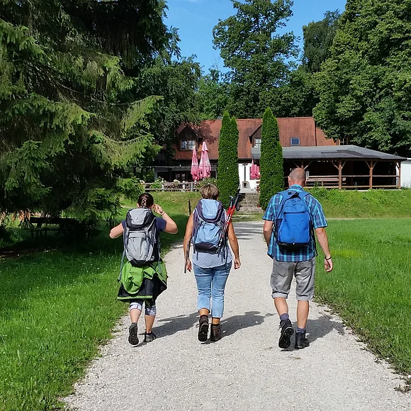 Wanderer auf den letzten Metern zur Einkehr in der Waldschänke Eisbrunn, die im Hintergrund zu sehen ist.