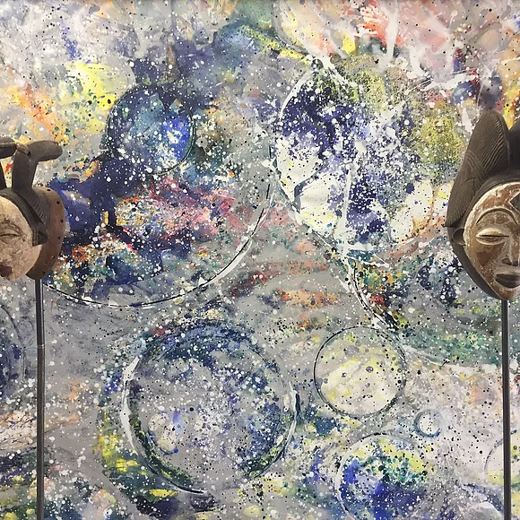 2 Masken vor einer bemalten Wand