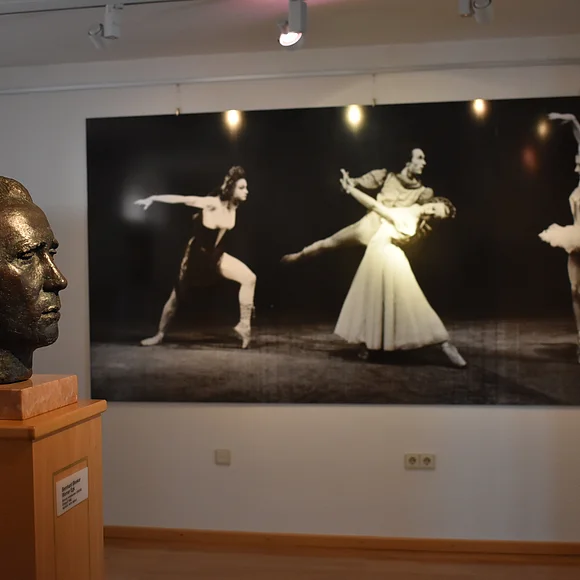 Werner-Egk-Begegnungsstätte im Käthe-Kruse-Puppen-Museum in Donauwörth Eine Büste von Werner Egk und Ballett-Bilder an der Wand