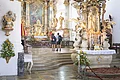Zwei Pilger stehen im Altarraum in der Wallfahrtsbasilika Maria Brünnlein und blicken zur Stuckdecke.