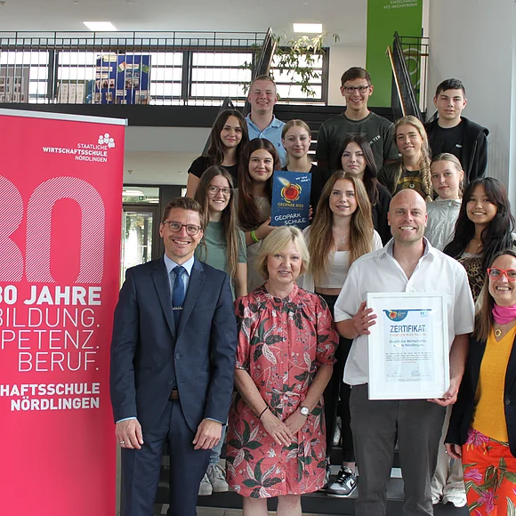 Gruppenfoto bei der Verleihung des Titels "Geopark Ries Schule" an die Wirtschaftsschule Nördlingen mit David Wittner, Manuela Stahl, Tobias Kreuzer, Heike Burkhardt und Schüler:innen.