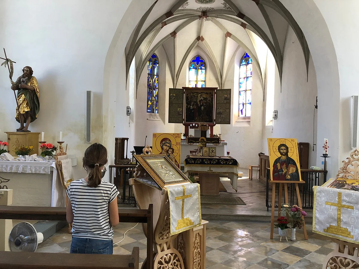 Innenraum der Friedhofskirche - Bänke, Altar, Heiligen Figuren.