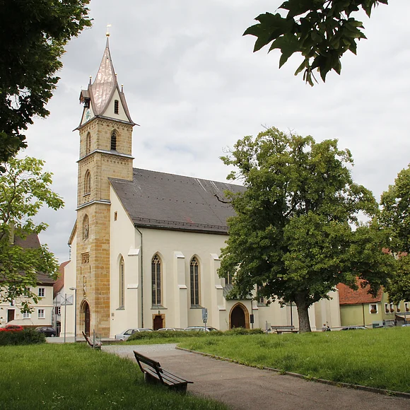 Außenansicht von St. Sebastian, Oettingen Blick auf die Pfarrkirche St. Sebastian, die teilweise hinter Bäumen verborgen ist.