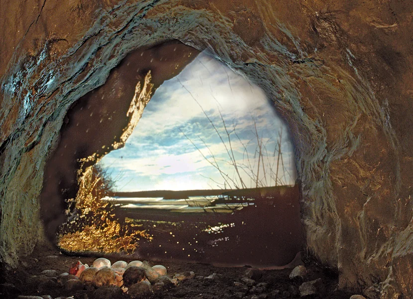 Am Boden einer nachgebildeten Höhle liegen mehrere Schädel.