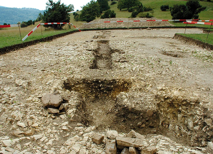 Auf einer Wiese befindet sich eine abgesperrte archäologische Ausgrabungsstätte.