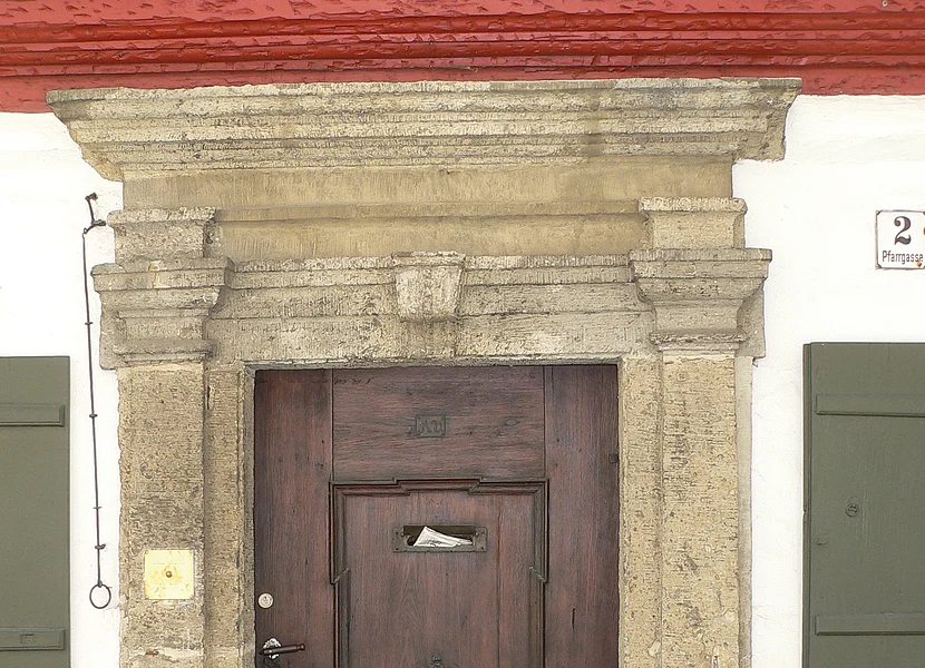 Portal aus Suevit Das Portal mit Gesims einer Holztür ist aus dem Gestein Suevit gefertigt.