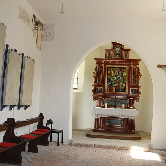 Blick in das schlichte Innere der Kapelle und auf den Altar mit dem Bild, das von dem verstorbenen Künstler Ernst Steinacker geschaffen wurde.