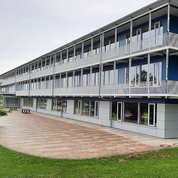 Grund- und Mittelschule Oettingen Seitliche Frontansicht der Grund- und Mittelschule Oettingen. Links im Bild ist ein Busch.