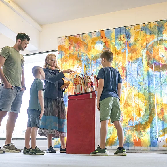 Eine Familie sieht sich im KunstMuseum ein Kunstwerk an.