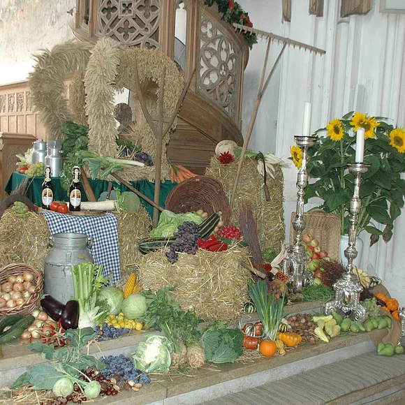 Die Erntedankdekoration mit zur Krone gebundenem Getreide und verschiedenem Obst und Gemüse.