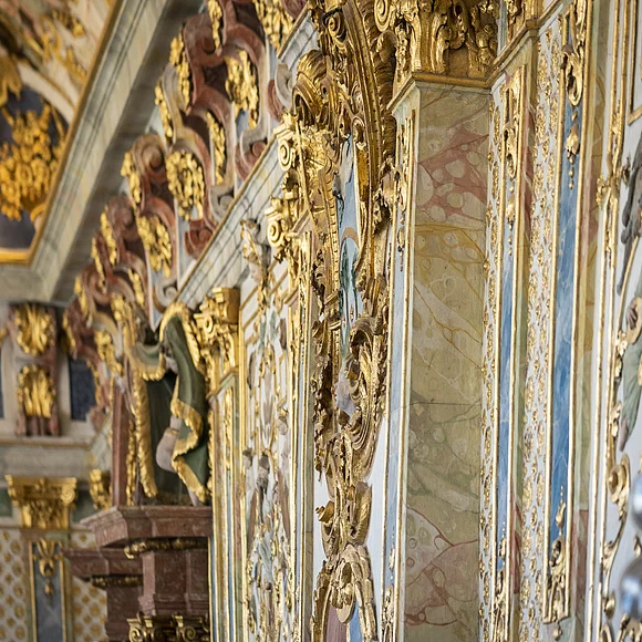 Wände des Kaisersaales in Kaisheim Detailaufnahme einer Wand mit barocker goldener Stuckverzierung und bemalten Figuren in einem historischen Gebäude.