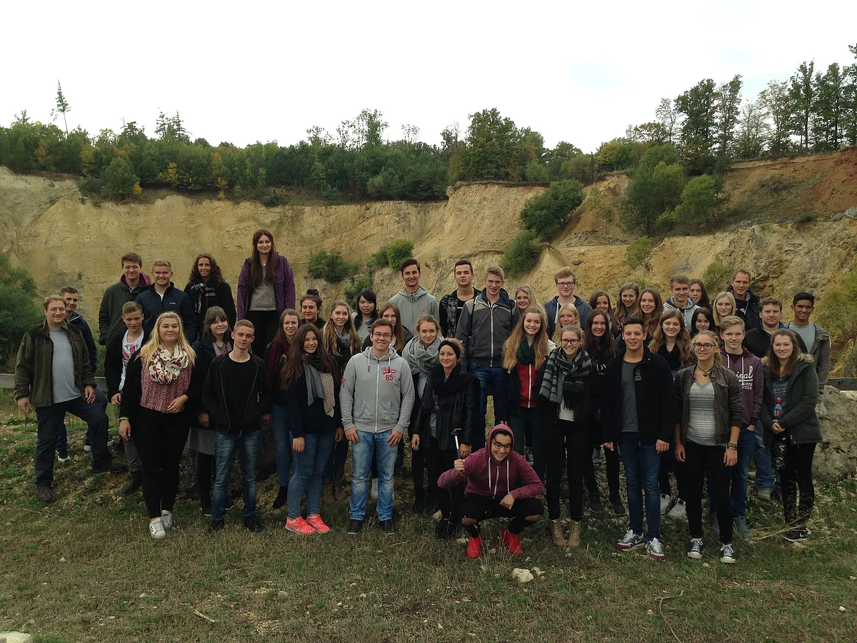 Eine große Gruppe junger Menschen steht in einem ehemaligen Steinbruch.