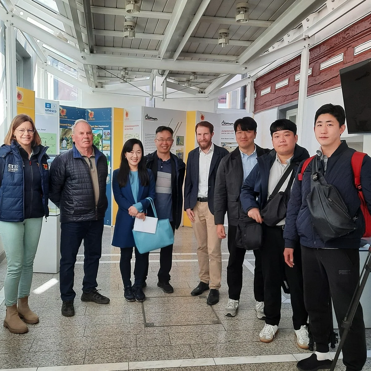 Gruppenbild mit mehreren Personen. Im Hintergrund sind Informationstafeln zu erkennen.