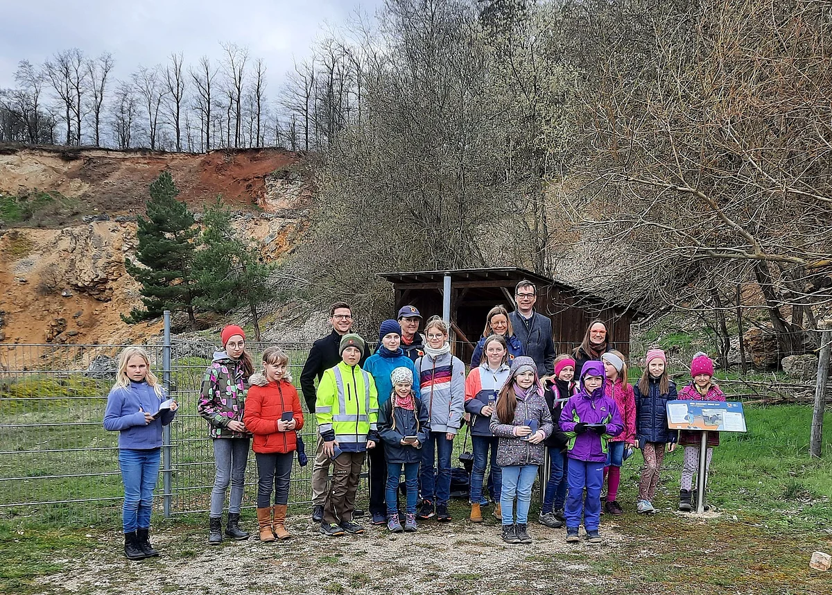 Eröffnung Kinder-Erlebnispfad Lindle Gruppenfoto mit Kindern in einem ehemaligen Steinbruch mit rötlichen Wänden.