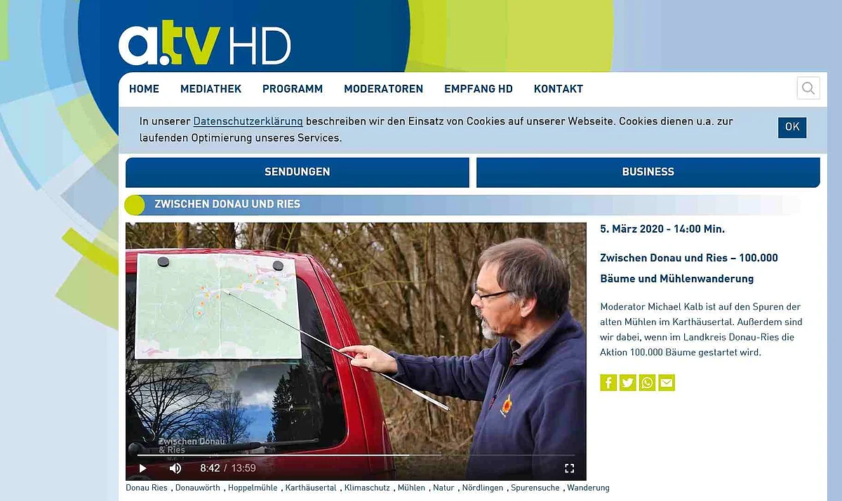 In einem Screenshot eines Videos des a.tv deutet ein Mann mit einem Zeigestab auf eine an einem Auto befestigte Landkarte.
