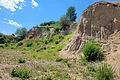 Steinbruchwand im Geotop Sandgrube "Am Limberg" mit blauem Himmel