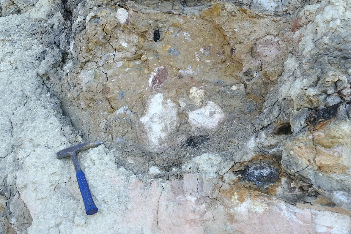 Bunte Breccie Bunte Breccie mit daneben liegendem Geologenhammer